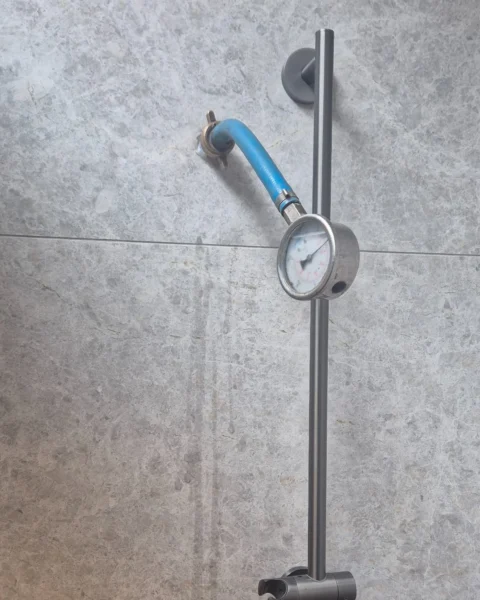 Shower water pressure testing in Canterbury using a pressure gauge during a residential leak investigation.