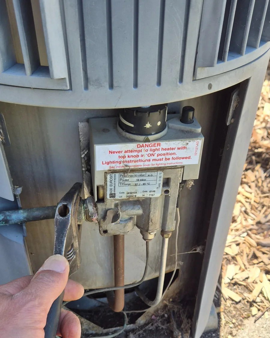 Old gas control valve being removed from a gas hot water system during repairs in Endeavour Hills.