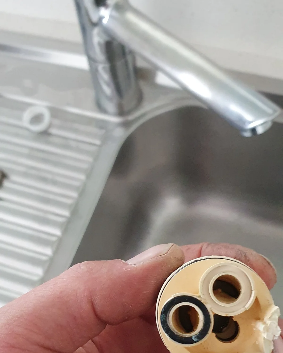 Removed mixer tap cartridge showing the internal component replaced during a leaking mixer tap repair.