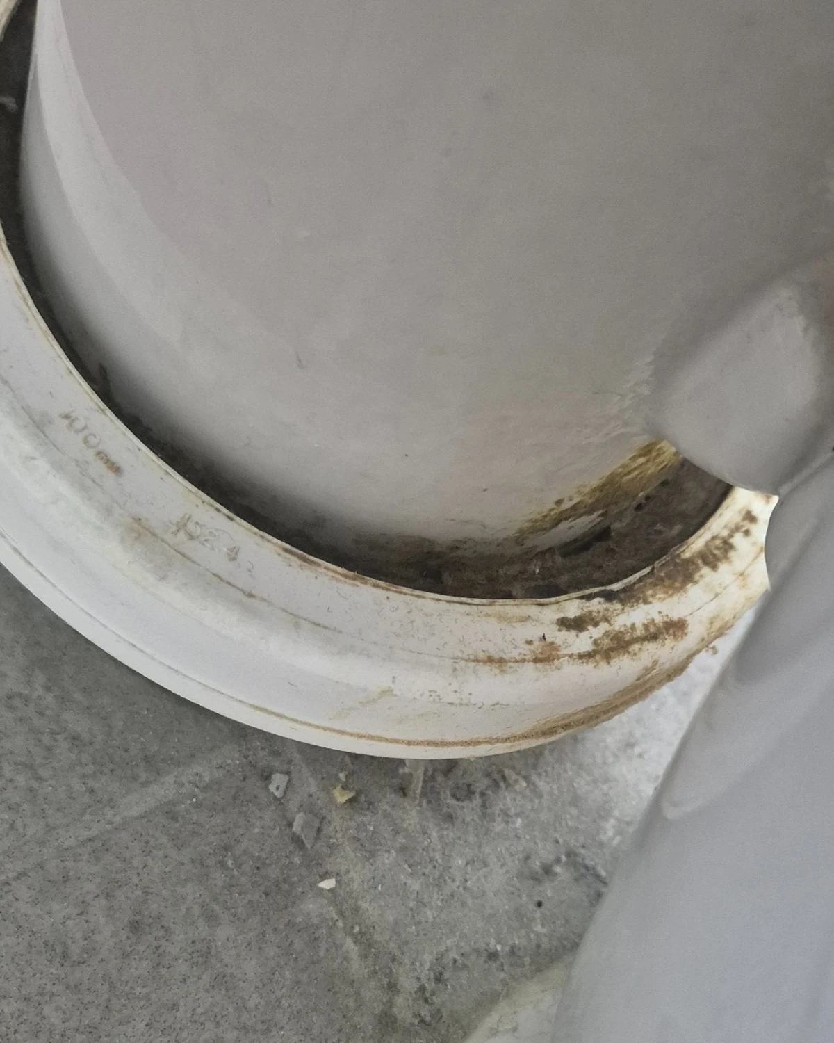 Close-up of sewer staining around a toilet pan connector showing toilet drainage or sealing issues.
