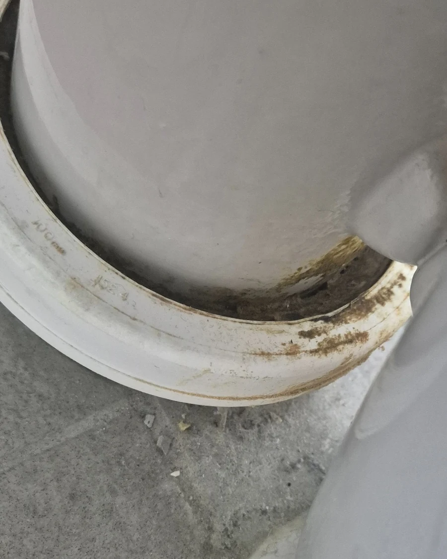 Close-up of sewer staining around a toilet pan connector showing toilet drainage or sealing issues.