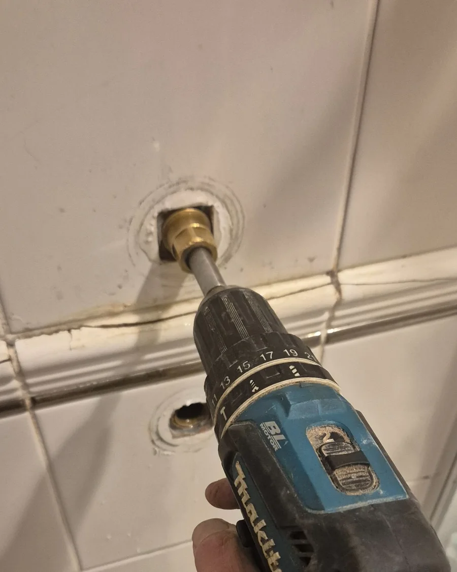 Tap seat being dressed inside a wall-mounted tap breech during a leaking tap repair.