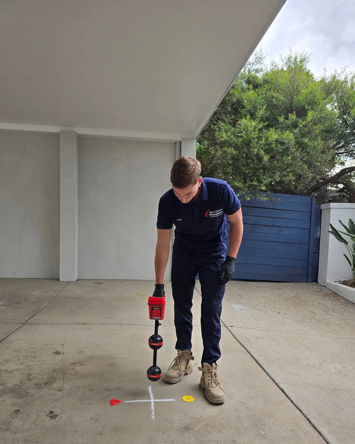 Your Choice Plumbers plumber locating an underground drain after CCTV inspection using professional pipe locating equipment.