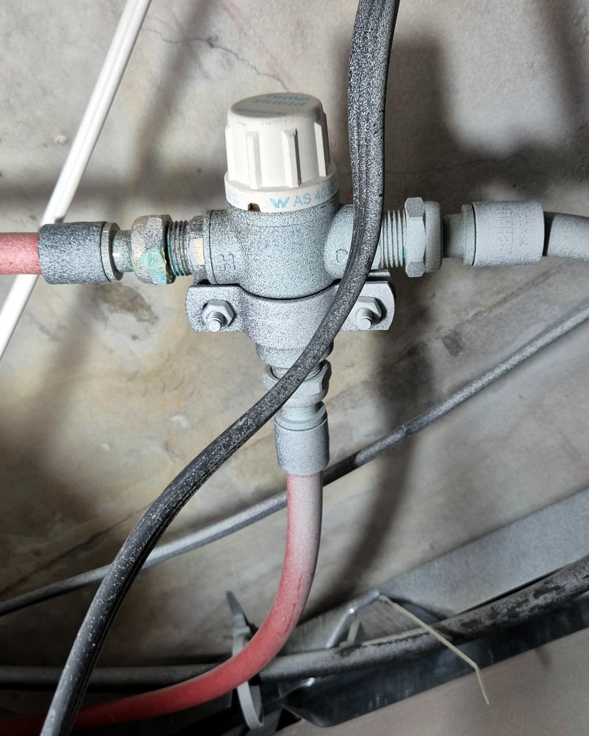 Existing apartment temperature control valve in ceiling space requiring replacement.