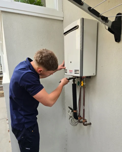 Your Choice Plumbers plumber inspecting a Rinnai continuous flow hot water system at a client’s home.