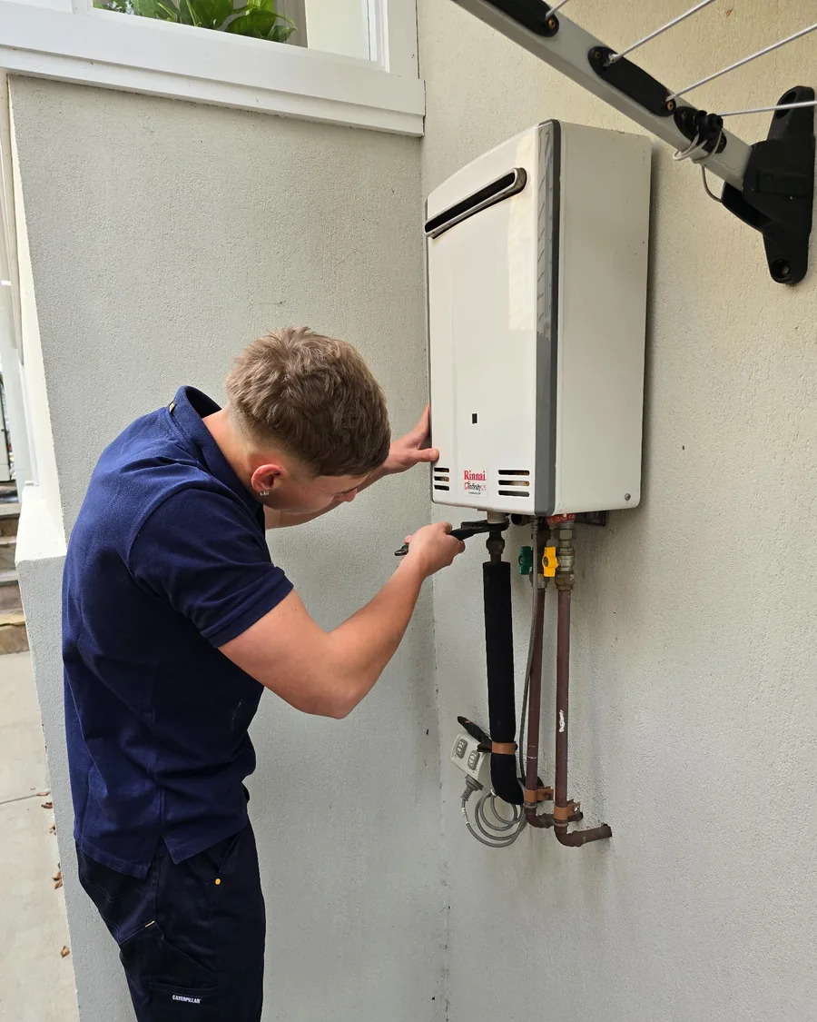 Your Choice Plumbers plumber inspecting a Rinnai continuous flow hot water system at a client’s home.