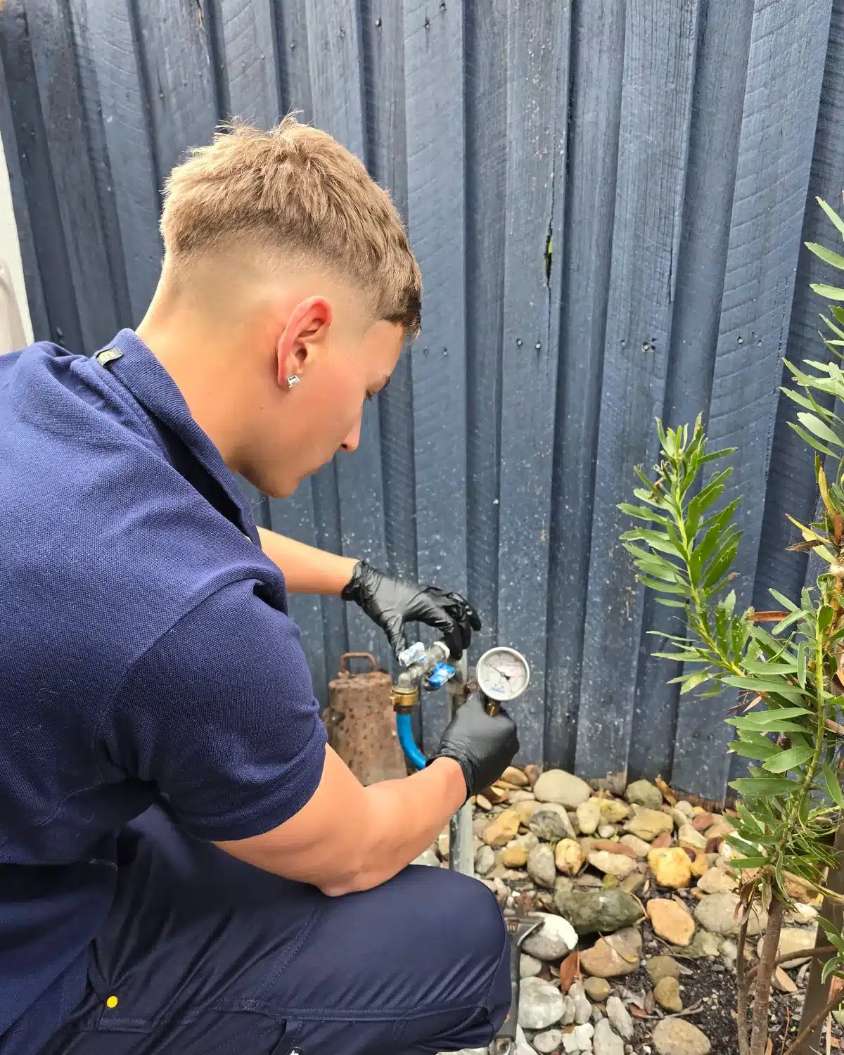 Your Choice Plumbers plumber checking water pressure at a client’s home using a water pressure gauge.